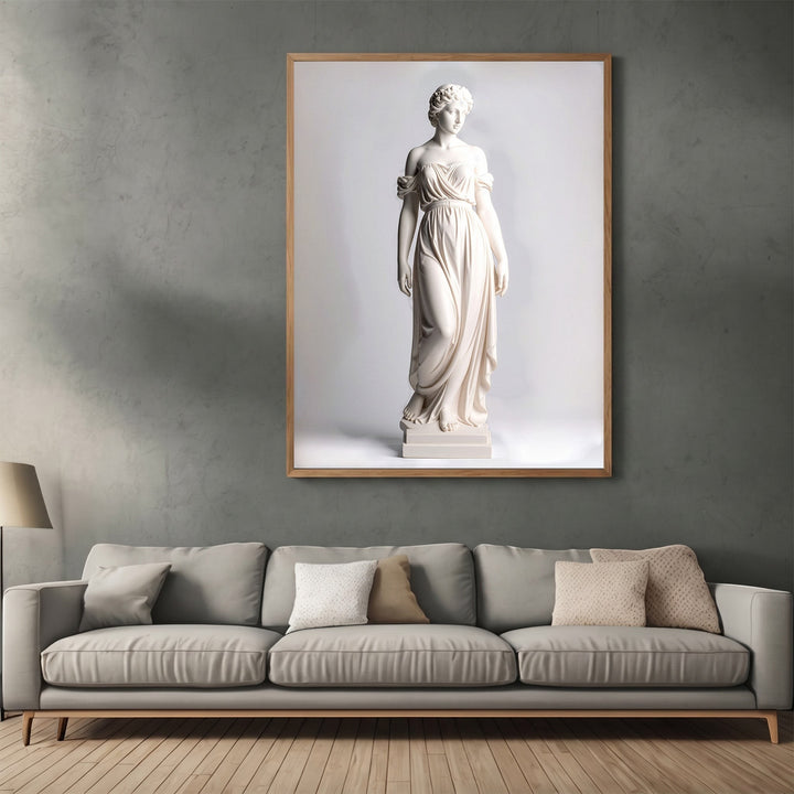 Wadi Home classical statue wall art print in a light wood frame hanging above a modern grey sofa in a living room.