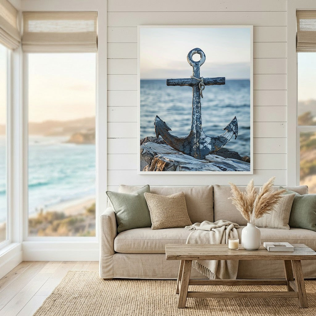 Wadi Home coastal anchor wall art print featuring a rustic metal anchor on a rocky shore above a beige living room sofa.