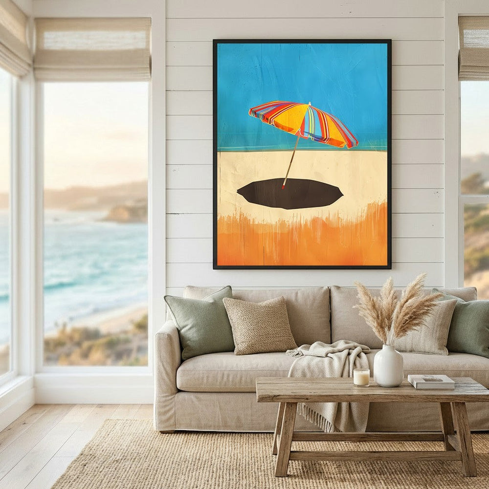 Wadi Home framed wall art featuring a vibrant striped beach umbrella on a sandy shore, displayed in a coastal living room