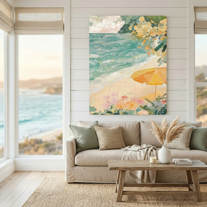 Wadi Home coastal beach scene framed wall art with turquoise ocean, yellow umbrella, and flowers above a beige sofa.