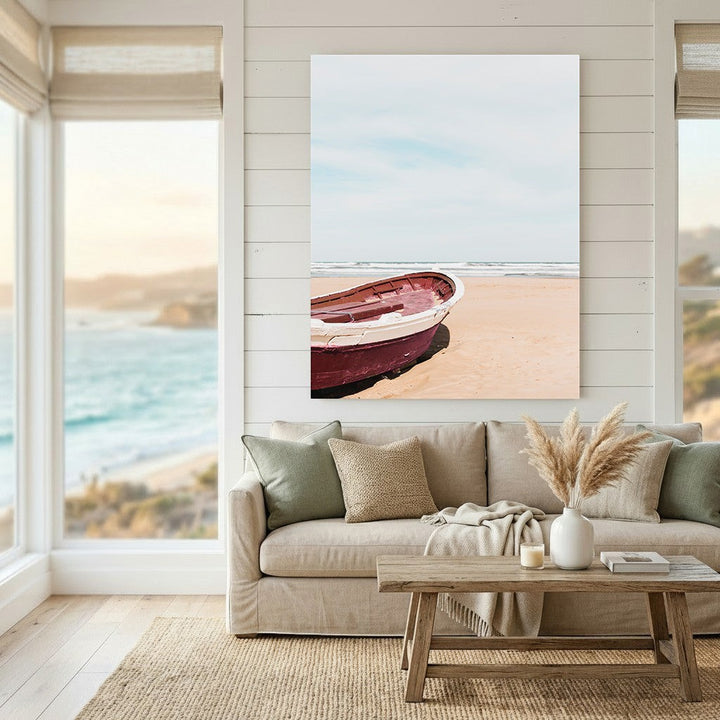 Wadi Home coastal wall art featuring a deep red boat on a sandy beach, displayed in a bright, modern living room.