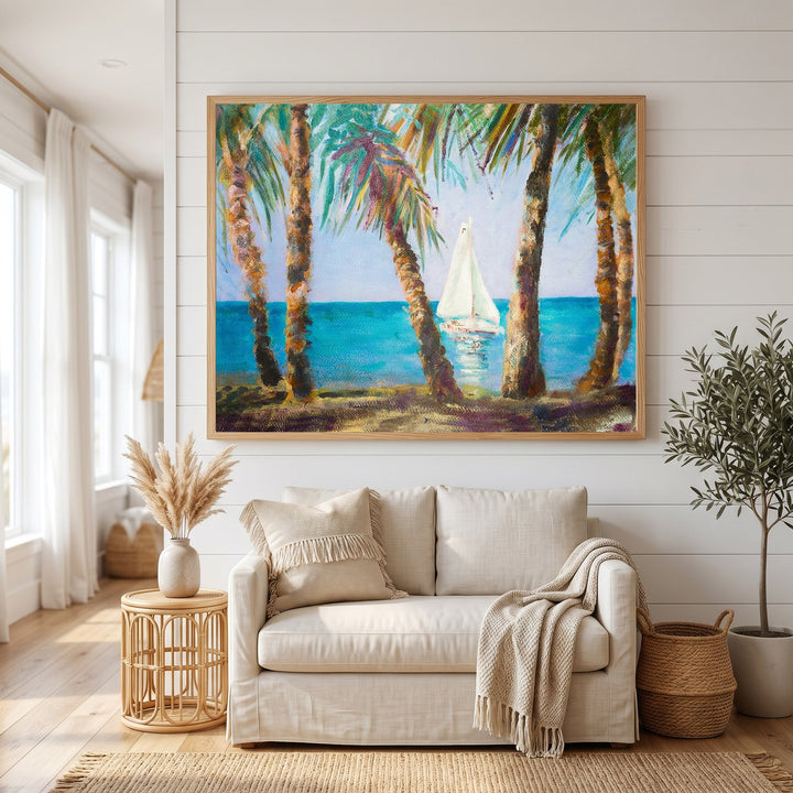 Wadi Home coastal sailboat landscape wall art in a wooden frame hanging above a beige sofa in a bright living room.
