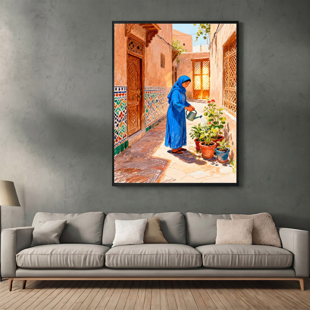 Wadi Home framed wall art featuring a woman in a blue dress watering plants in a traditional sunlit courtyard.