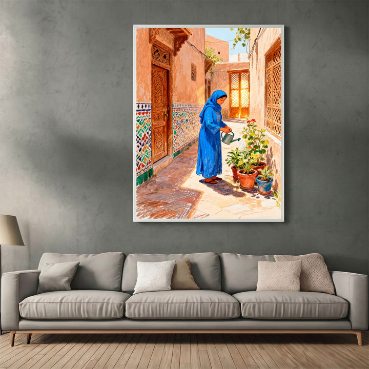 Wadi Home framed wall art featuring a woman in a blue dress watering plants in a traditional sunlit courtyard.