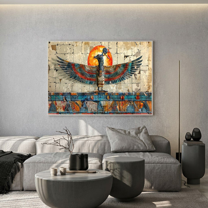 Wadi Home Ancient Egyptian winged deity wall art featuring a glowing sun above a modern grey living room sofa.