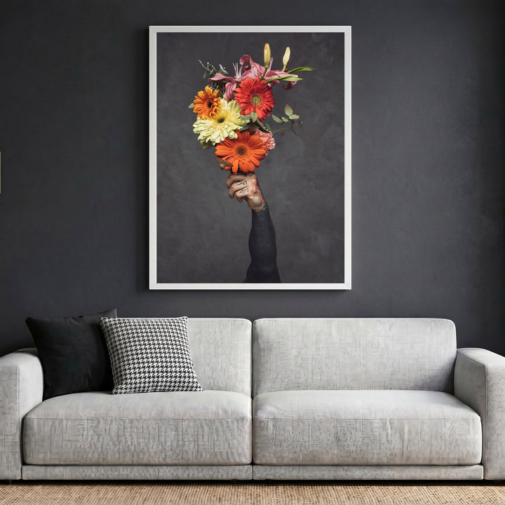 Wadi Home framed wall art print featuring a tattooed hand holding a vibrant floral bouquet against a dark grey wall.