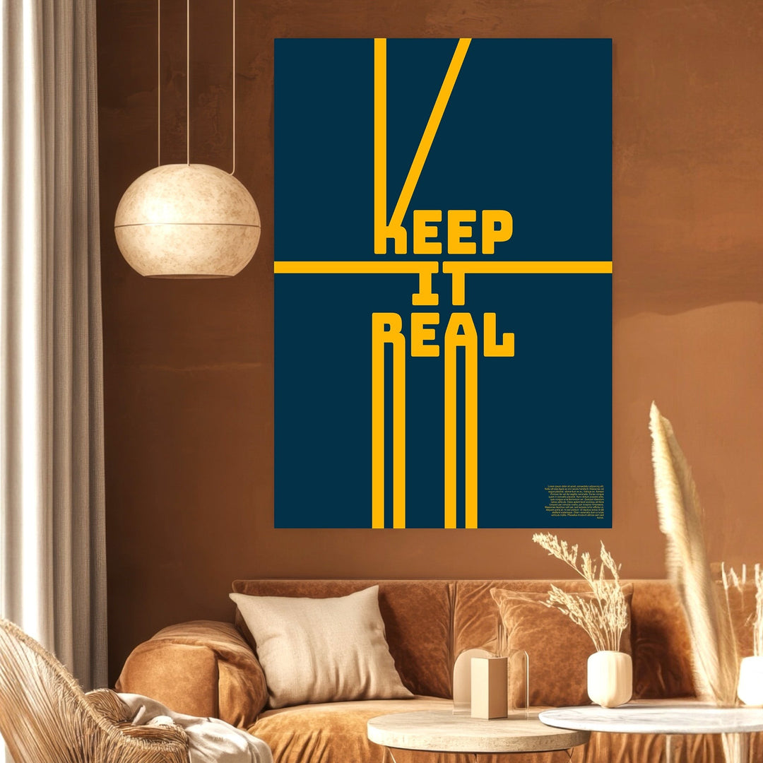 Wadi Home Keep It Real typography poster with yellow text on a navy blue background displayed in a modern living room.