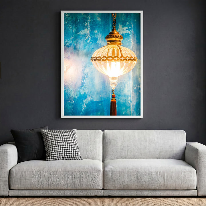 Wadi Home decorative wall art print featuring a glowing lantern against a textured blue background above a sofa.