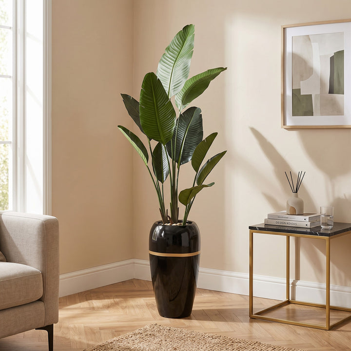 Wadi Home Large Bird of Paradise artificial plant with lush green leaves in a tall black pot with gold accent.