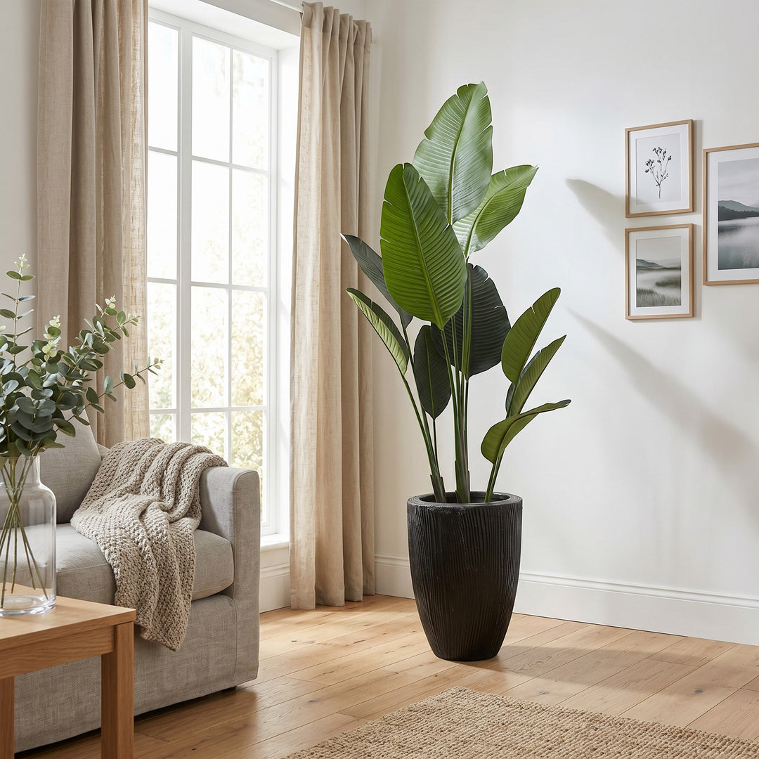 Wadi Home Large Bird of Paradise artificial plant with lush green leaves in a textured black planter.
