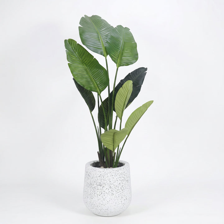 Wadi Home Large Bird of Paradise artificial plant with lush green leaves in a speckled white pot.