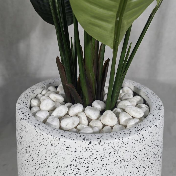 Wadi Home Large Bird of Paradise artificial plant with lush green leaves in a speckled white pot with white stones.