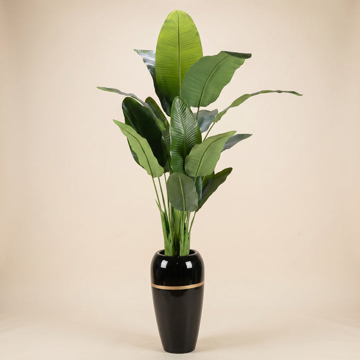 Wadi Home Large Faux Bird of Paradise plant with lush green leaves in a black pot with gold band.