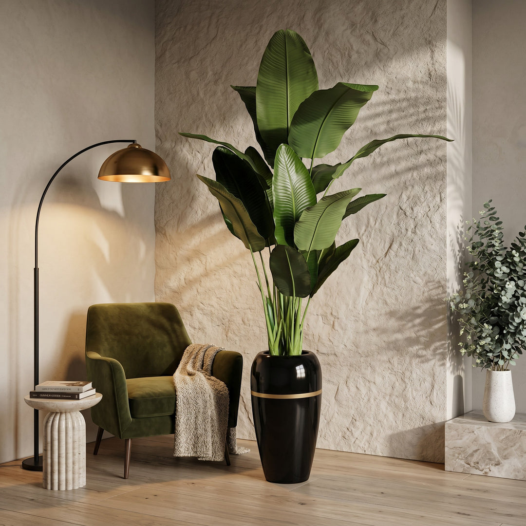 Wadi Home Large Faux Bird of Paradise Plant in a glossy black pot with gold trim. Lush green leaves.