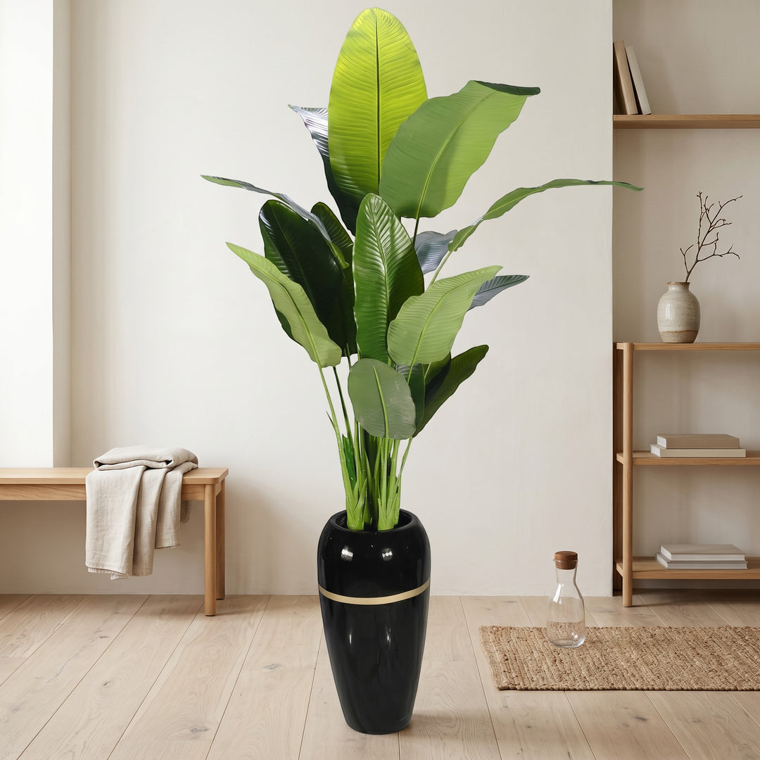 Wadi Home Large Faux Bird of Paradise plant with lush green leaves in a tall black pot with gold accent.