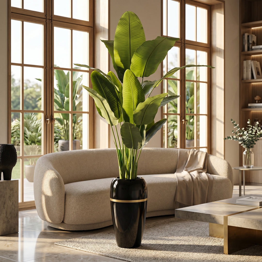 Wadi Home Large Faux Bird of Paradise plant with lush green leaves in a tall black pot with gold accent.