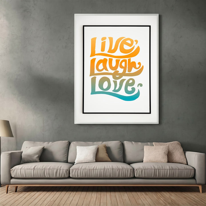 Wadi Home framed wall art with groovy Live Laugh Love typography in orange, yellow, and teal gradients above a sofa.