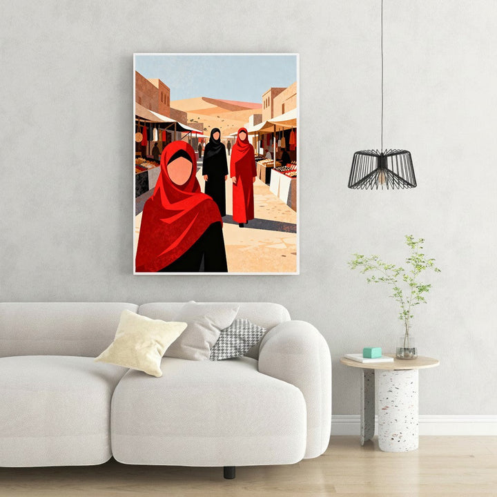 Wadi Home art print of women in traditional red and black attire walking through a vibrant marketplace with stalls and desert dunes in the background.