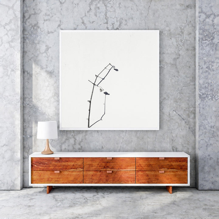 Wadi Home minimalist framed print of a delicate black branch with two small birds against a white background.