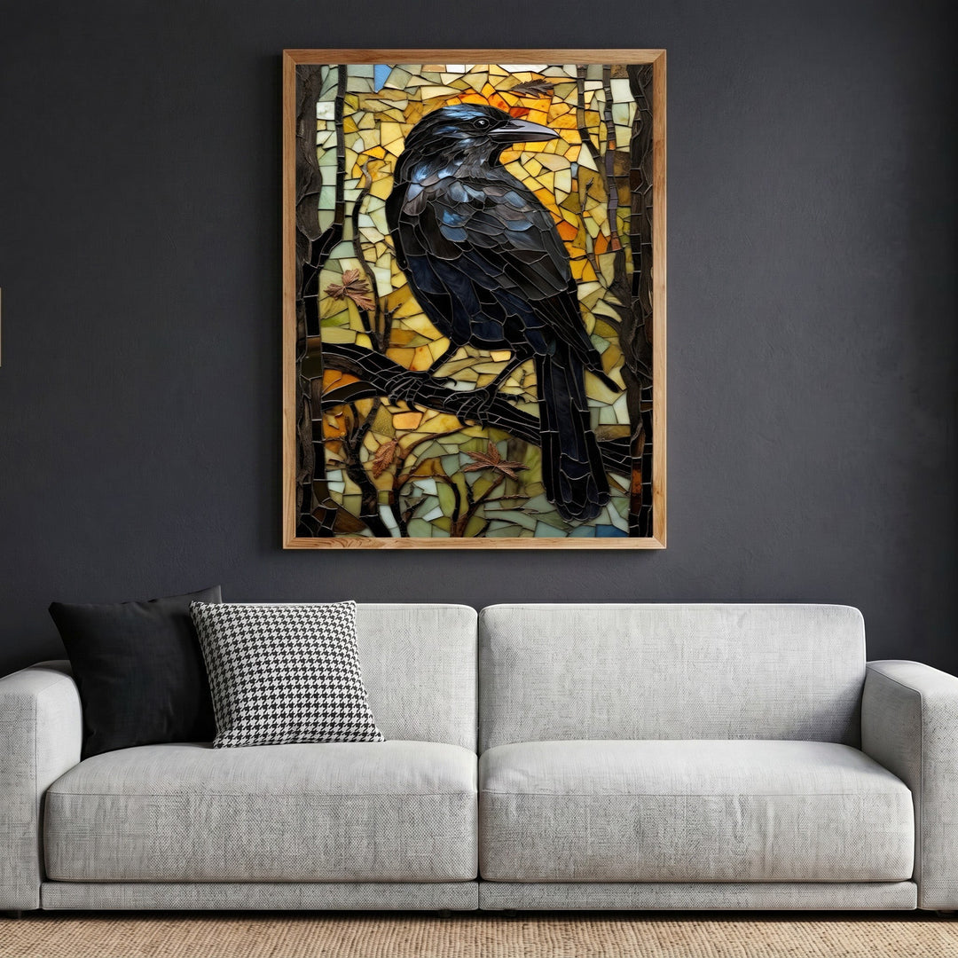 Wadi Home mosaic raven wall art in a wooden frame hanging above a modern grey sofa in a living room.