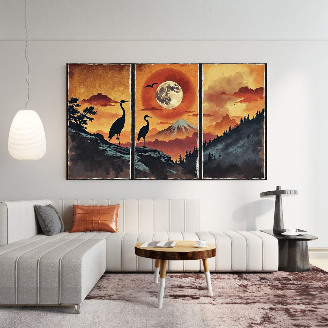 Wadi Home Serene Mountain Landscape Triptych Wall Art featuring silhouetted cranes, a full moon, and a mountain under a sunset sky. Watercolor texture.