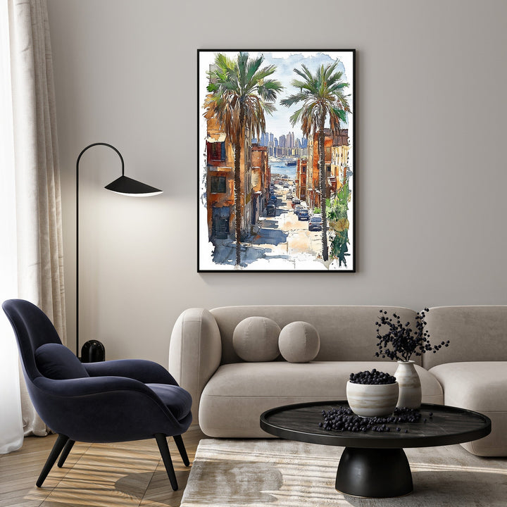 Wadi Home watercolor art of a city street with palm trees, cars, and buildings leading to a bay.