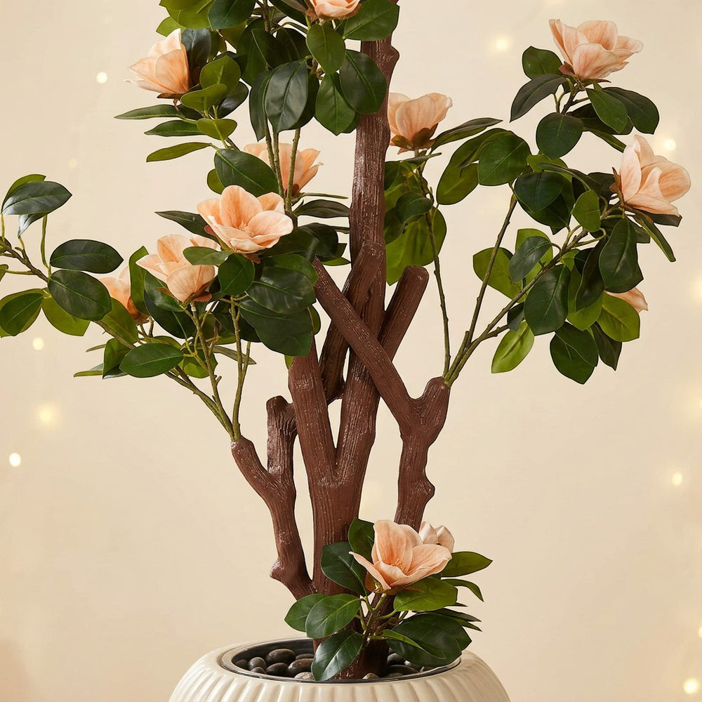 Wadi Home faux tree with soft peach blossoms and green leaves in a ribbed white planter.