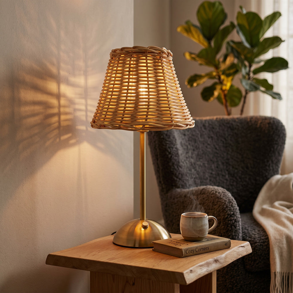 Wadi Home woven rattan table lamp with brushed brass base, casting intricate shadows on the wall.