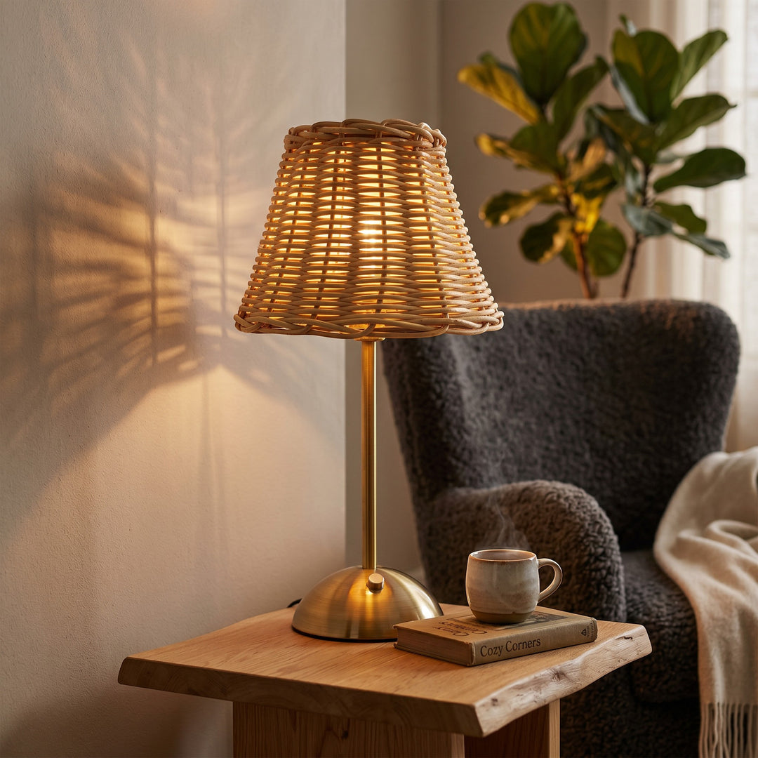 Wadi Home woven rattan table lamp with brushed brass base, casting intricate shadows on the wall.