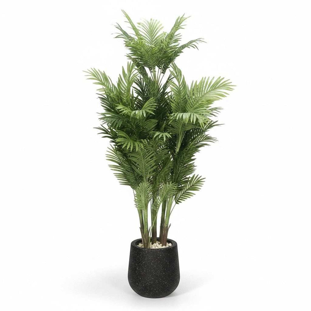 Wadi Home tall faux Areca palm tree with lush green fronds in a black speckled planter with white stones.