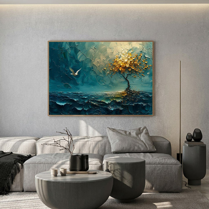 Wadi Home textured landscape wall art with deep teal ocean and golden tree, framed above a modern grey sofa.