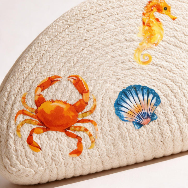 Wadi Home beige woven half moon clutch bag featuring colorful crab, seahorse, and seashell summer beach prints.
