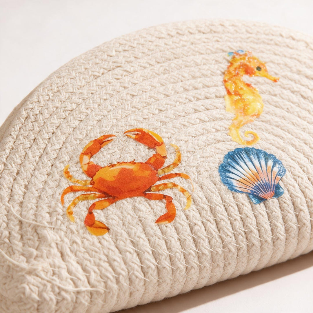 Wadi Home beige woven half moon clutch bag featuring colorful crab, seahorse, and seashell beach-themed prints.