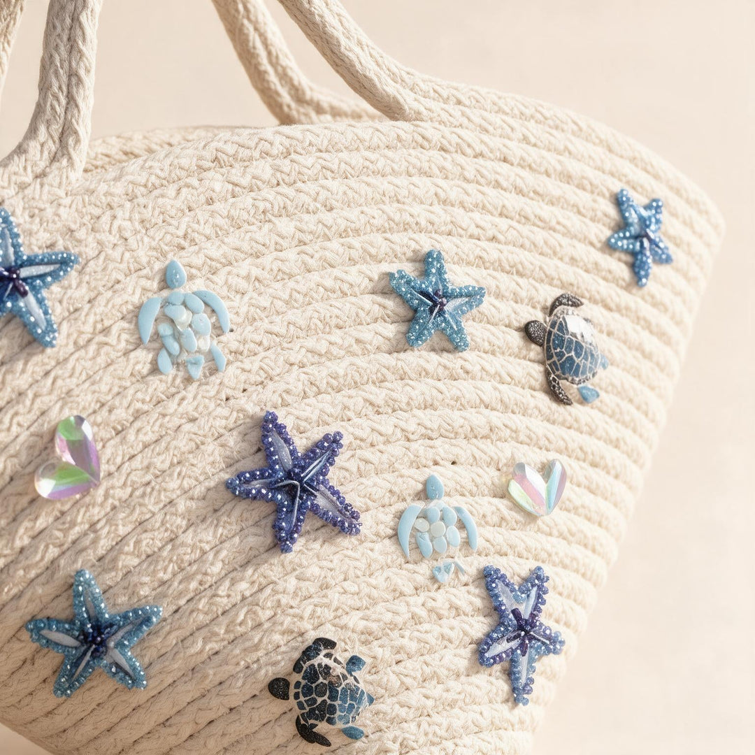 Wadi Home off-white woven beach tote bag featuring blue beaded starfish and sea turtle embellishments.