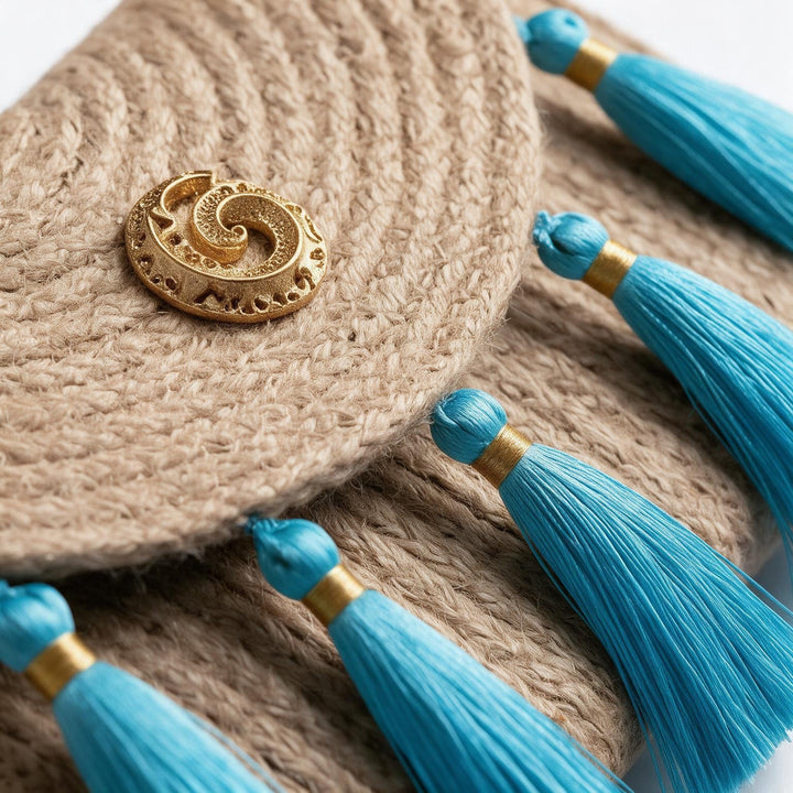 Wadi Home woven jute clutch handbag featuring turquoise tassels and a decorative gold-tone spiral metal accent