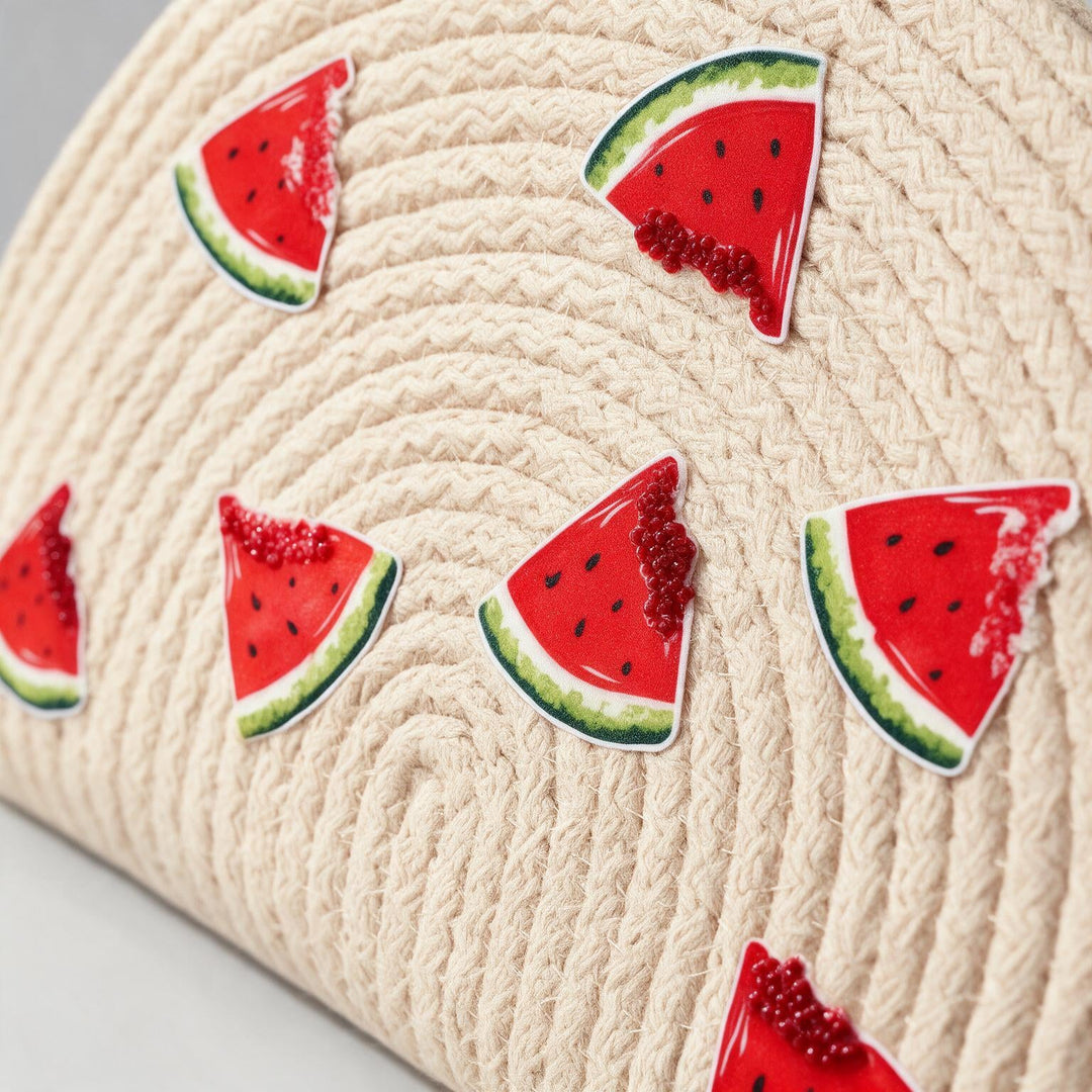 Wadi Home beige woven half moon clutch with playful watermelon slice prints, perfect for summer beach outings.