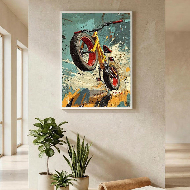 Wadi Home dynamic yellow bicycle art print with red accents, mid-air action, abstract energetic background.