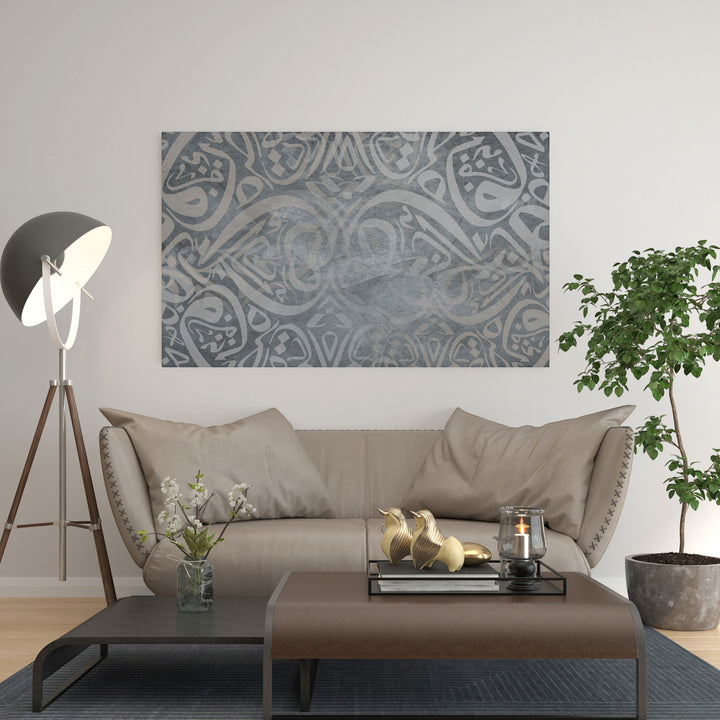Wadi Home abstract Arabic calligraphy art in grey tones, framed and displayed above a sofa.