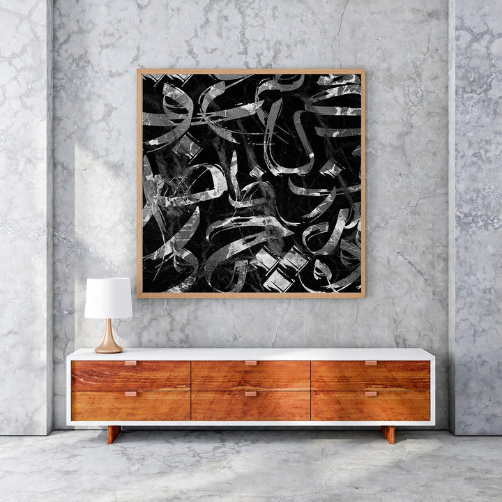 Wadi Home abstract calligraphy wall art with black and silver brushstrokes in a wooden frame.