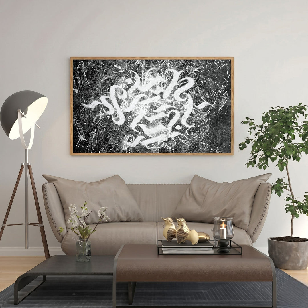 Wadi Home abstract calligraphy wall art with white brushstrokes on textured black background, framed in light wood.