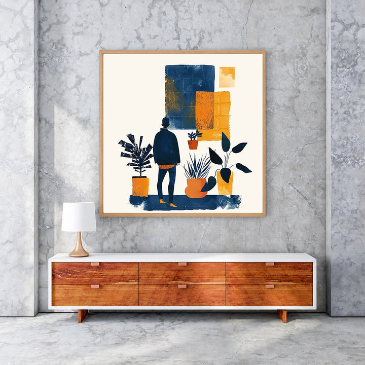 Wadi Home abstract wall art with blue and orange figure and plants. Framed artwork on concrete wall.