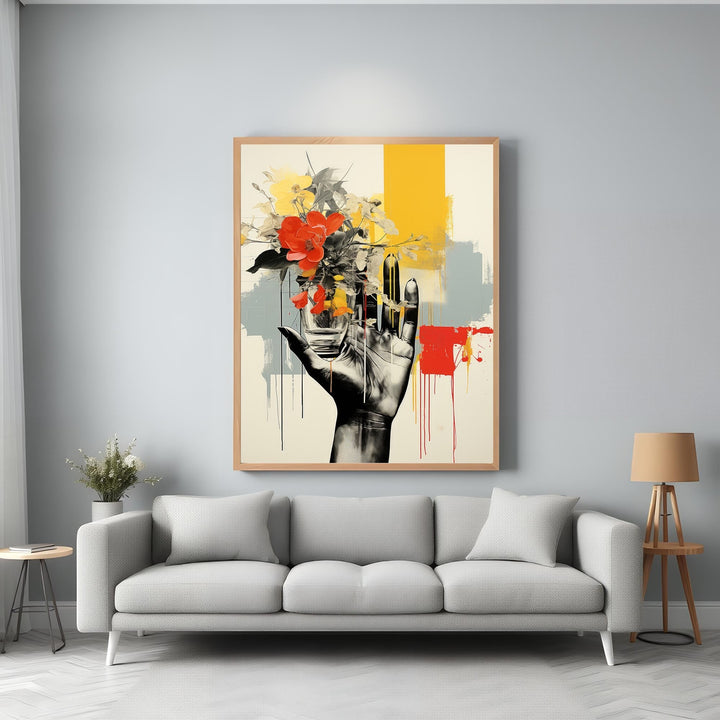 Wadi Home abstract wall art: hand holding vibrant red and yellow flowers against bold yellow, grey, and red abstract strokes.