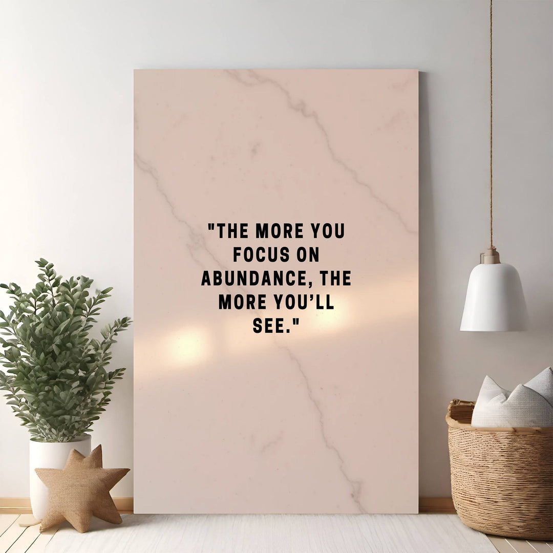 Wadi Home inspirational wall art with "The more you focus on abundance, the more you'll see." quote on marble background.