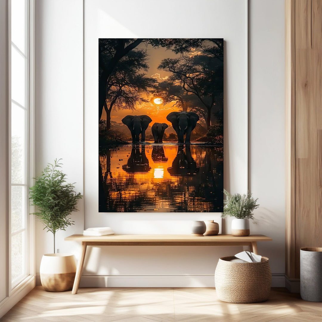 Wadi Home African Sunset Elephant Gathering wall art features a herd of elephants at sunset reflected in water. Vibrant oranges and purples.
