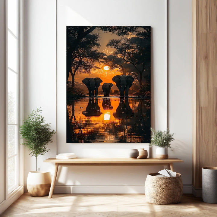 Wadi Home African Sunset Elephant Gathering wall art features a herd of elephants at sunset reflected in water. Vibrant oranges and purples.