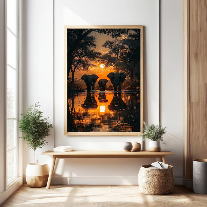 Wadi Home African Sunset Elephant Gathering wall art, featuring elephants silhouetted against a vibrant orange sunset reflected in water.