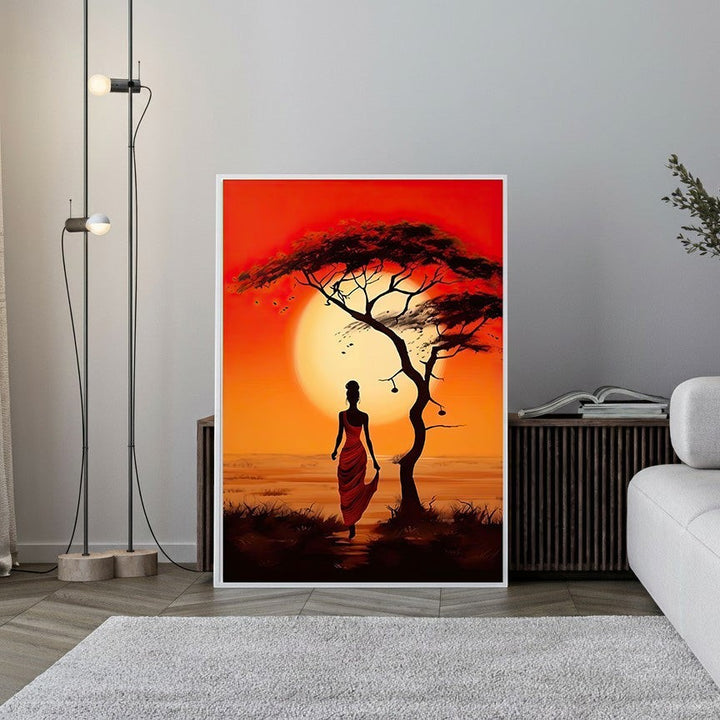Wadi Home African Sunset landscape art print featuring a woman in a red dress walking towards a lone acacia tree during a vibrant orange and red sunset.
