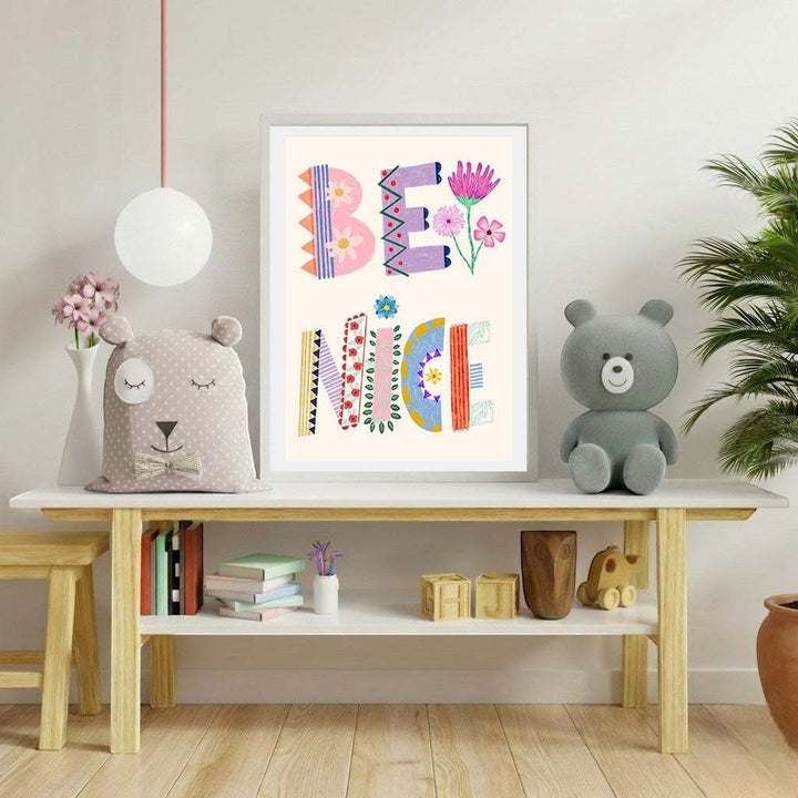 Wadi Home framed "Be Nice" typography art print with colorful letters, floral accents, and playful patterns. Ideal for nurseries.