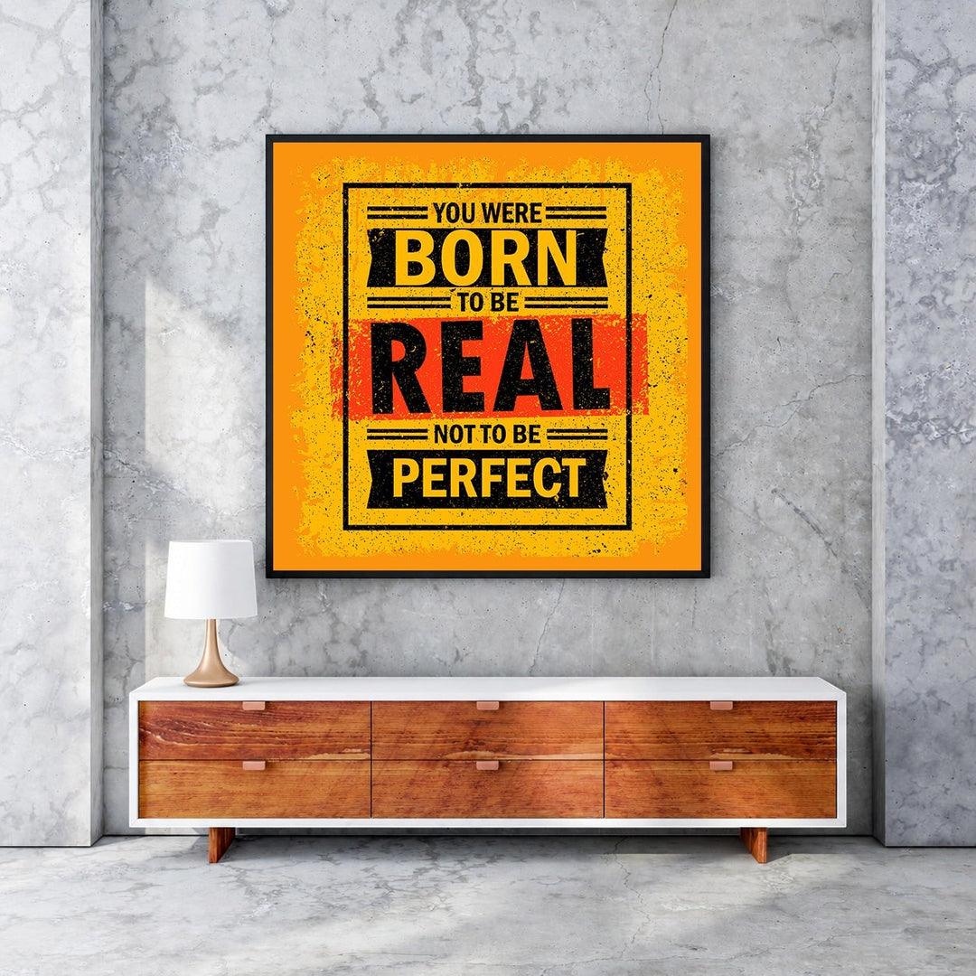 Wadi Home motivational wall art with bold yellow, black, and red typography reading 'You Were Born To Be Real Not To Be Perfect'.