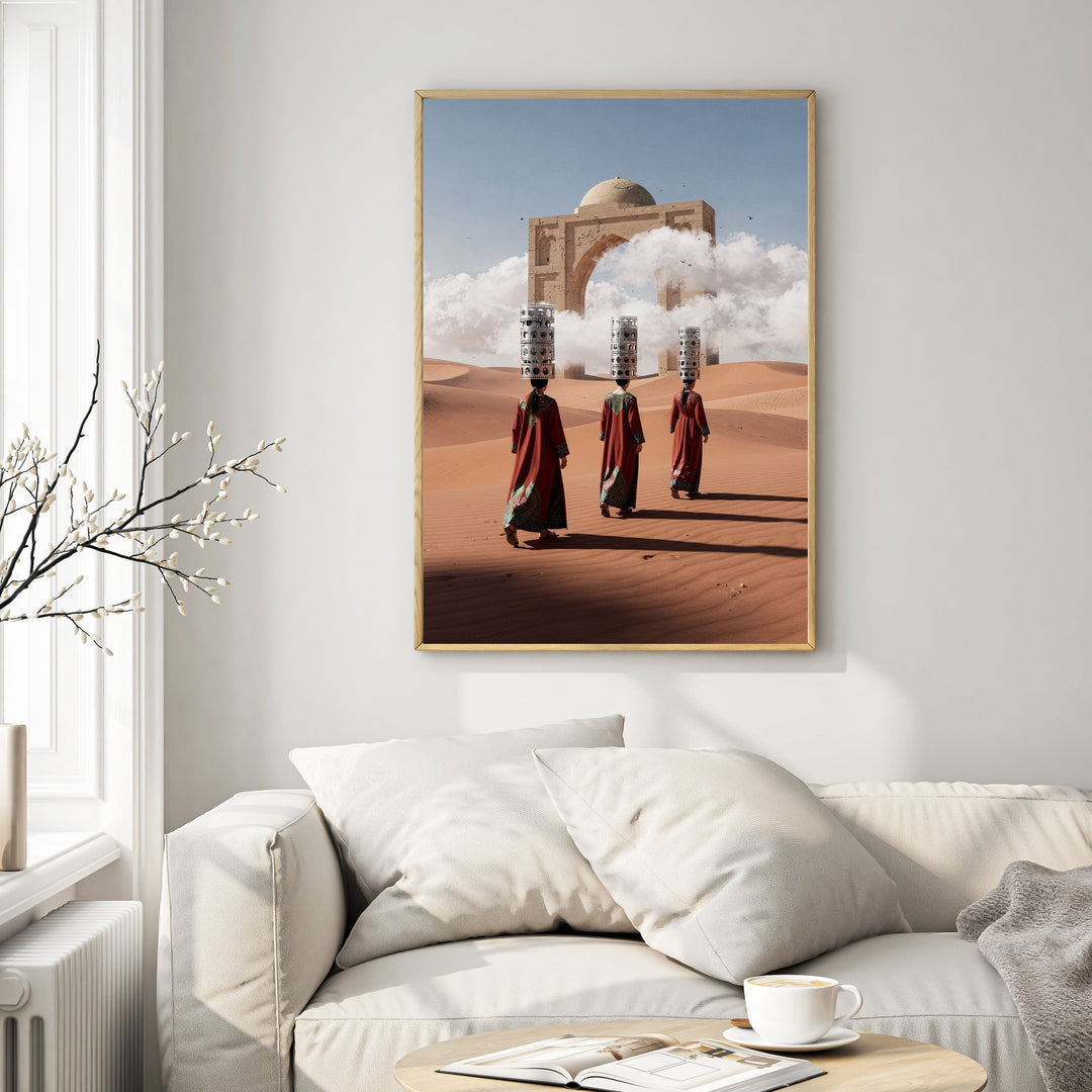 Wadi Home art print: Three figures in traditional robes carry burdens across a desert landscape towards an ancient archway framing a domed structure.